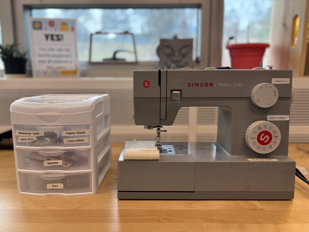 A Singer Heavy Duty sewing machine and a labelled notions organizer at the Makerspace textile station. The space is about more than technology, hands-on crafting tools are available to every TRU student at no cost. (Singh, 2026)